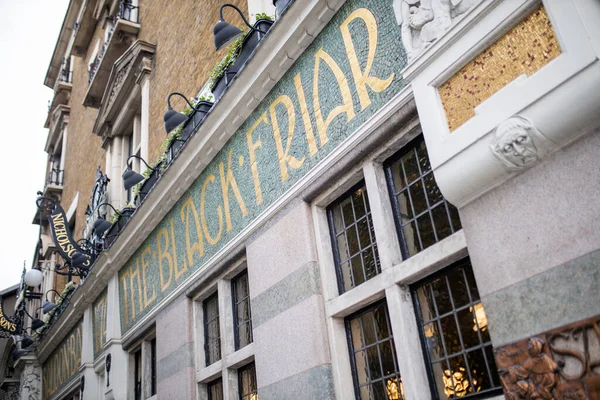 British pub with its green and golden signboard on a wall over some windows — Fotografia de Stock