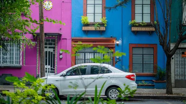하얀 승용차 - 코요 아칸의 이웃에 사는 두 개의 다채 로운 집 밖에 있다 — 스톡 사진