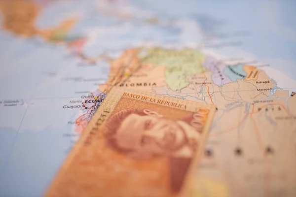 Billete de mil pesos colombianos por debajo de Colombia en un mapa colorido y borroso — Foto de Stock