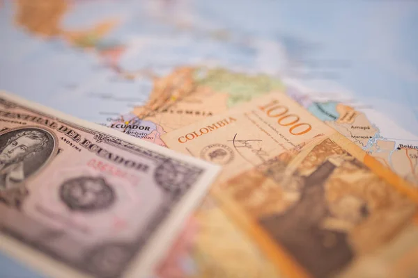 Cinco sucres y un billete de 1000 pesos por debajo de Ecuador y Colombia en un mapa — Foto de Stock