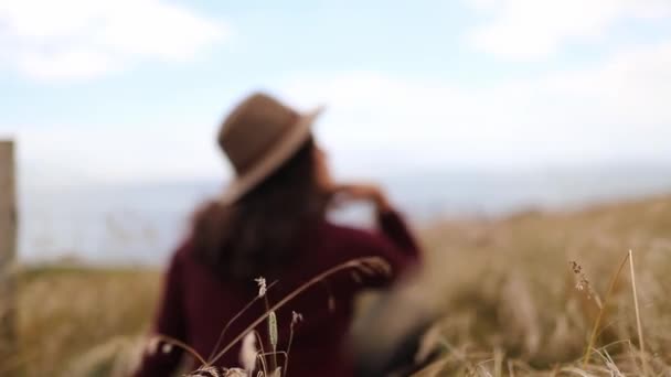 Woman Resting in Tall Dry Grass with the Blue Sky as Background — Stockvideo