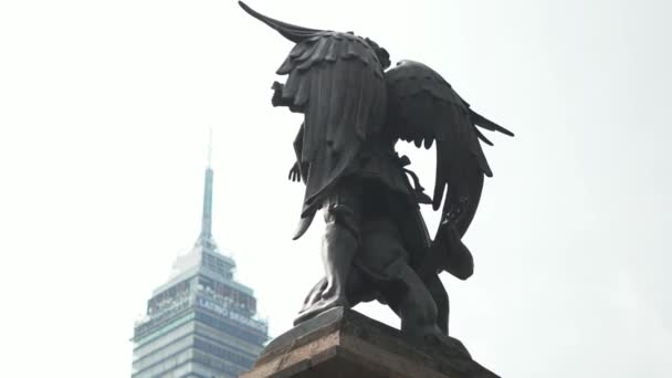 Estatua de un hombre y un ángel con la torre latinoamericana en el fondo — Vídeo de stock