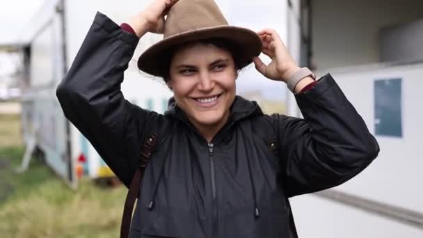 Mujer sonriente con un sombrero rodeado de pequeñas empresas — Vídeo de stock