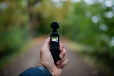 Landscape View Holding a DJI Osmo Pocket Camera Recording a Blurry Forest