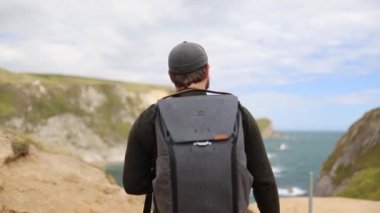 Man Enjoying the View of the Jurassic Coast During a Windy Day