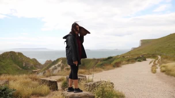 Woman Standing on a Big Rock with the Jurassic Coast as Background — Stock Video