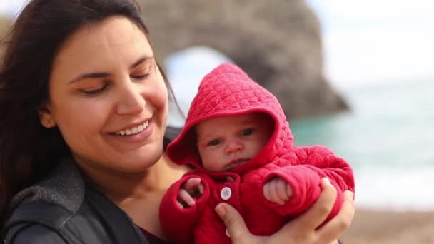 Mother Holding and Kissing her Baby with the Durdle Door as Background — Wideo stockowe