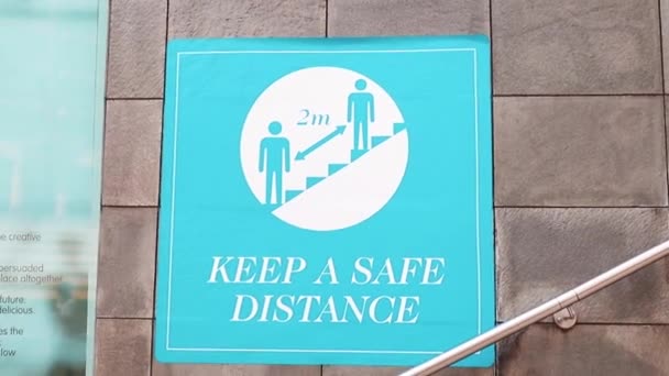 Blaues "Sicherheitsabstand" -Schild neben der Treppe — Stockvideo