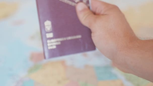 Рука имеет паспорт Швеции перед красочной картой Европы — стоковое видео