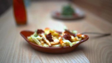 Patates kızartması, kabaklı şehriye ve ahşap masada bir tuvalet şişesi.
