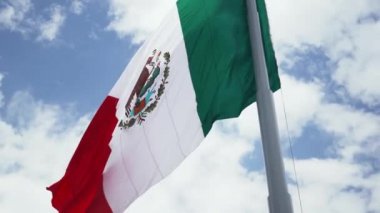Mexican Flag Waving in the Wind and a Cloudy Sky as the Background