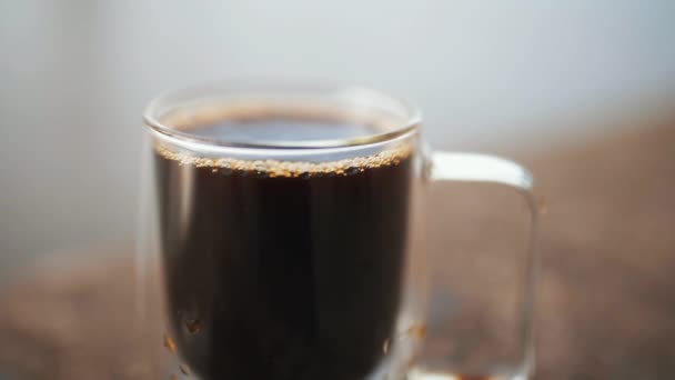 Tasse à café en verre au-dessus d'une surface en béton avec un fond gris et flou — Video