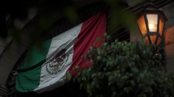Мексиканский флаг, висящий над входом в здание с дугой — стоковое видео
