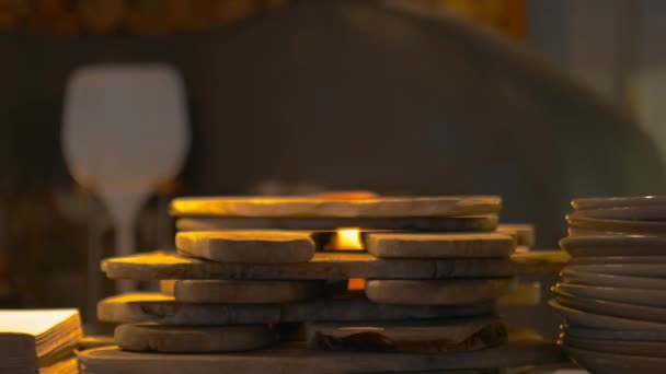 Vista de cerca de pequeñas tablas apiladas con un horno de fuego borroso como fondo — Vídeos de Stock