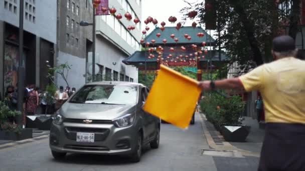 Hombre guiando el tráfico con una puerta tradicional china como fondo — Vídeos de Stock
