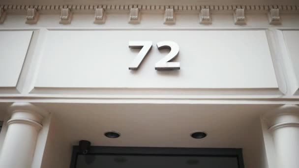 Adres numer 72 na białym budynku nad wejściem. — Wideo stockowe