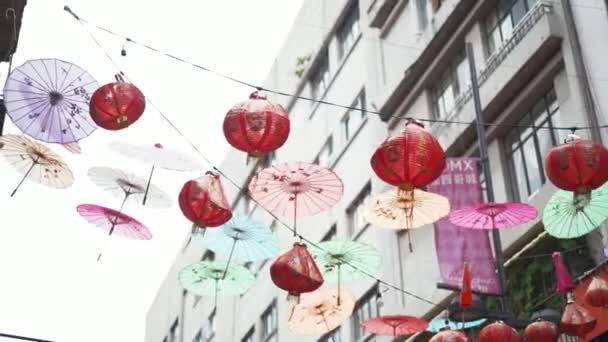 Traditional Chinese Lamps and Umbrellas Hanging Over the Chinatown Alley — Stockvideo