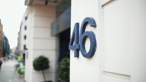 Address number 46 on a wall next to the entrance of a white building — Video Stock