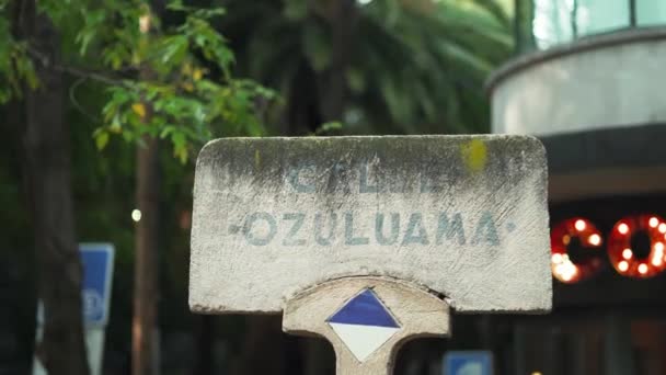 Señal de piedra de una calle llamada Ozuluama con una tienda de chocolate como fondo — Vídeo de stock