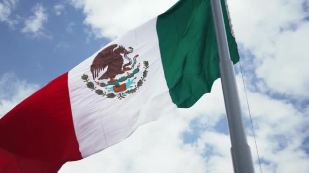 Bandera Mexicana ondeando al viento y un cielo nublado como telón de fondo — Vídeos de Stock