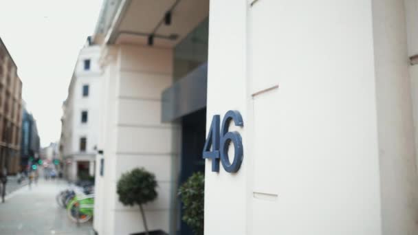 Address number 46 on a wall next to the entrance of a white building — Stok video