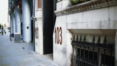 103 numaralı adres mermer görünümlü bir binanın girişinin yanında.