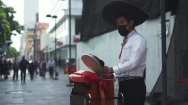Mexican Organ Grinder Wearing a Classic Mexican Attire Asking for Tips