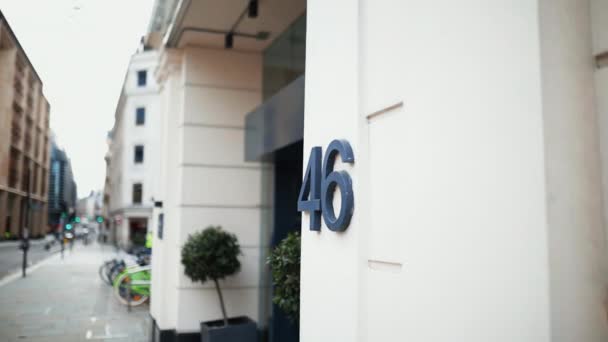 Dirección número 46 en una pared junto a la entrada de un edificio blanco — Vídeo de stock