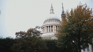 Klasik bir kırmızı Londra otobüsünün ve bazı ağaçların arkasındaki Aziz Paul Katedrali.