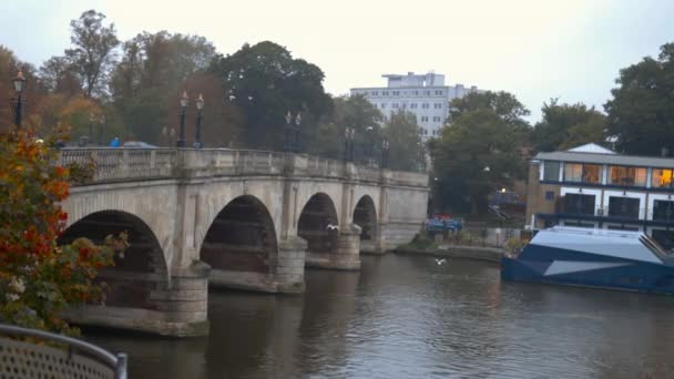 Blick auf eine Betonbrücke über einen Fluss und darauf fahrende Fahrzeuge — Stockvideo