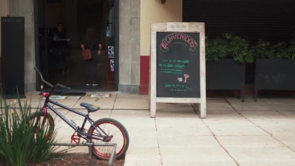 Bicicleta estacionada na calçada fora de um pequeno restaurante — Vídeo de Stock