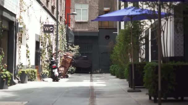 Motocicleta estacionada fuera de un baño público en un callejón — Vídeos de Stock