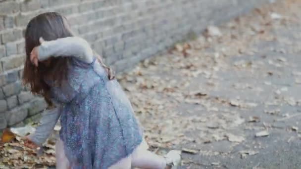 Little girl moves her hair after standing up from the sidewalk — Wideo stockowe