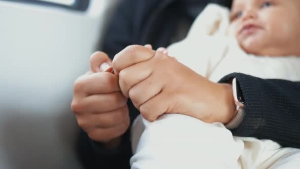 Mâinile unei femei decojind fistic în timp ce fiica ei se odihnește în poală — Videoclip de stoc