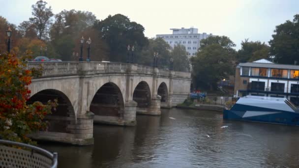 Vista panorámica de un puente de hormigón sobre un río y con vehículos sobre él — Vídeo de stock