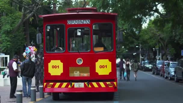 Tram rouge et jaune garé dans une rue du quartier appelé Coyoacan — Video