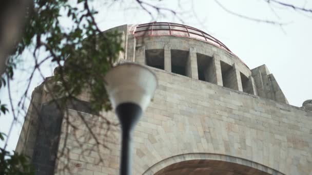 Monument voor de revolutie achter een boom en een lantaarnpaal — Stockvideo