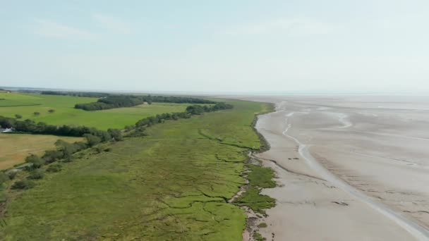 Aerial Landscape View of a Skyline over a Vast Grassland alongside the Wet Sand — Stockvideo