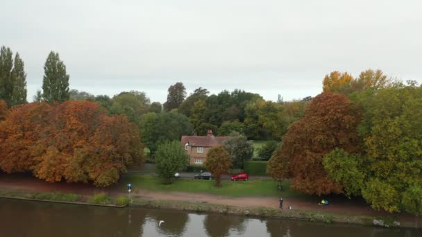 Vista aérea de una casa rodeada de árboles al otro lado del río — Vídeos de Stock