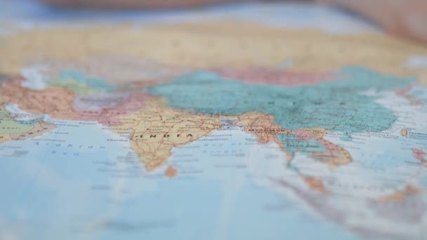 Ázsia elmosódott és színes térképe egy rózsaszín ceruzával a kezével. — Stock videók