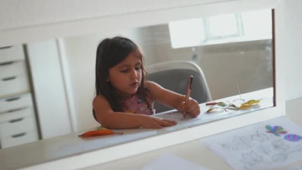 Espelho refletindo o interior de uma sala e uma menina coloração com uma caneta — Vídeo de Stock