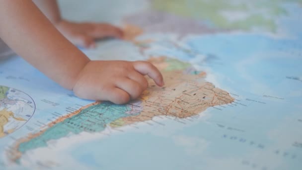 Le mani di una bambina su una mappa colorata del Sud America che punta al Brasile — Video Stock