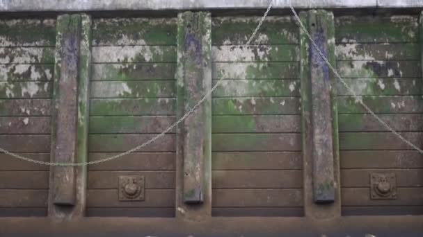Vista decrescente de uma parede de concreto acorrentado parcialmente coberto por Moss — Vídeo de Stock