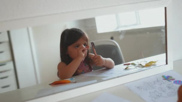 Specchio che riflette l'interno di una stanza e una bambina che gioca con una penna — Video Stock