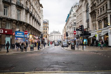 Front view of a narrow one-way street surrounded by pedestrians and buildings