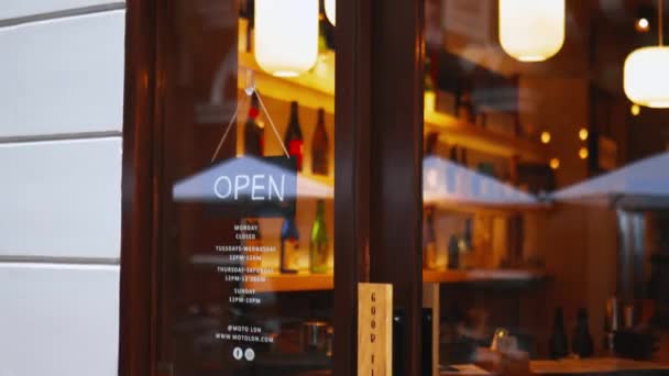 Quick close up of an Open sign hanging on the glass door of a Japanese sake bar — Wideo stockowe