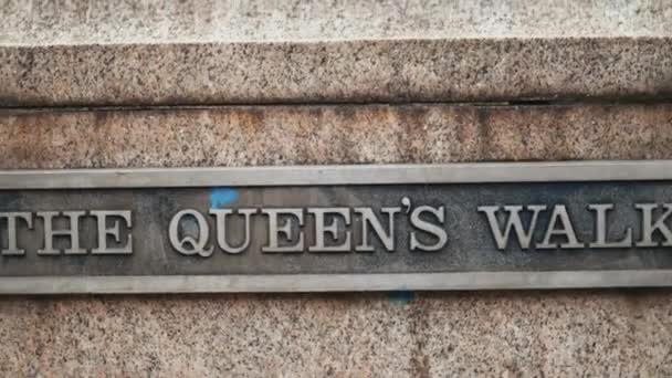 La placa de metal Queens Walk en una pared de hormigón con un poste de luz negro detrás — Vídeos de Stock