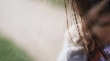 Küçük kız sakince yeşil koyun yemi tutuyor, çiftlik hayvanlarını beslemeye hazırlanıyor.