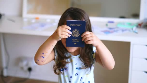 Szczęśliwa dziewczynka zabawnie ukrywa się za amerykańskim paszportem — Wideo stockowe