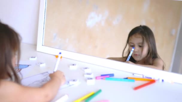Menina refletida em um espelho para colorir com um marcador azul — Vídeo de Stock